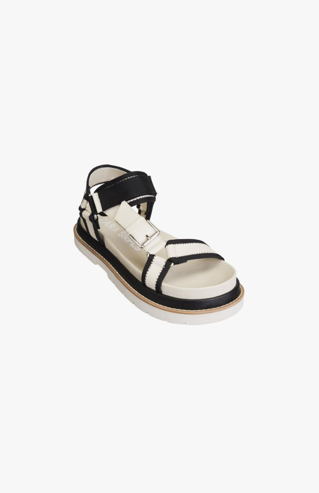 Zapato tipo sandalia plana de piel de color blanco. 