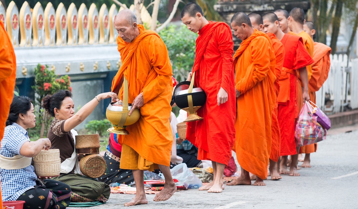 monjes budistas recogiendo comida
