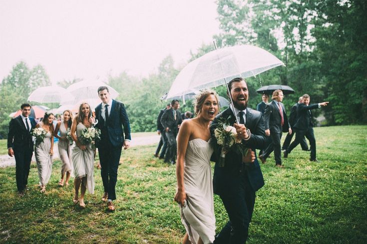 Personas de una boda huyendo de la lluvia.