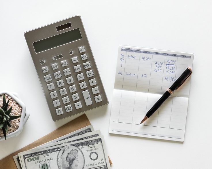 Una calculadora y una libreta para hacer el cálculo de un presupuesto.